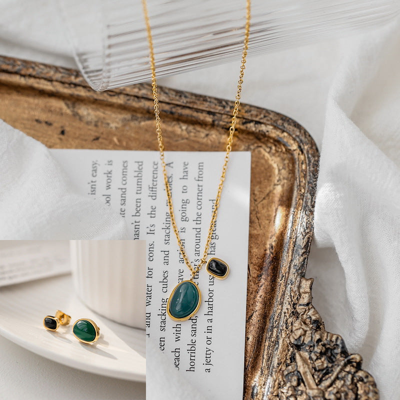 Parure di collana con pendente e orecchini in malachite d'ispirazione vintage in acciaio al titanio con finitura galvanica e design asimmetrico