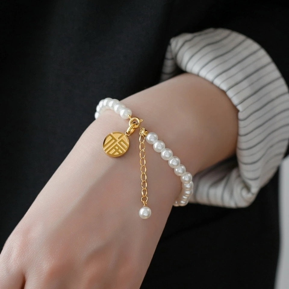 Bracciale minimalista geometrico in acciaio al titanio con pendente a carattere "Fu" placcato oro 18K e nappe di perle
