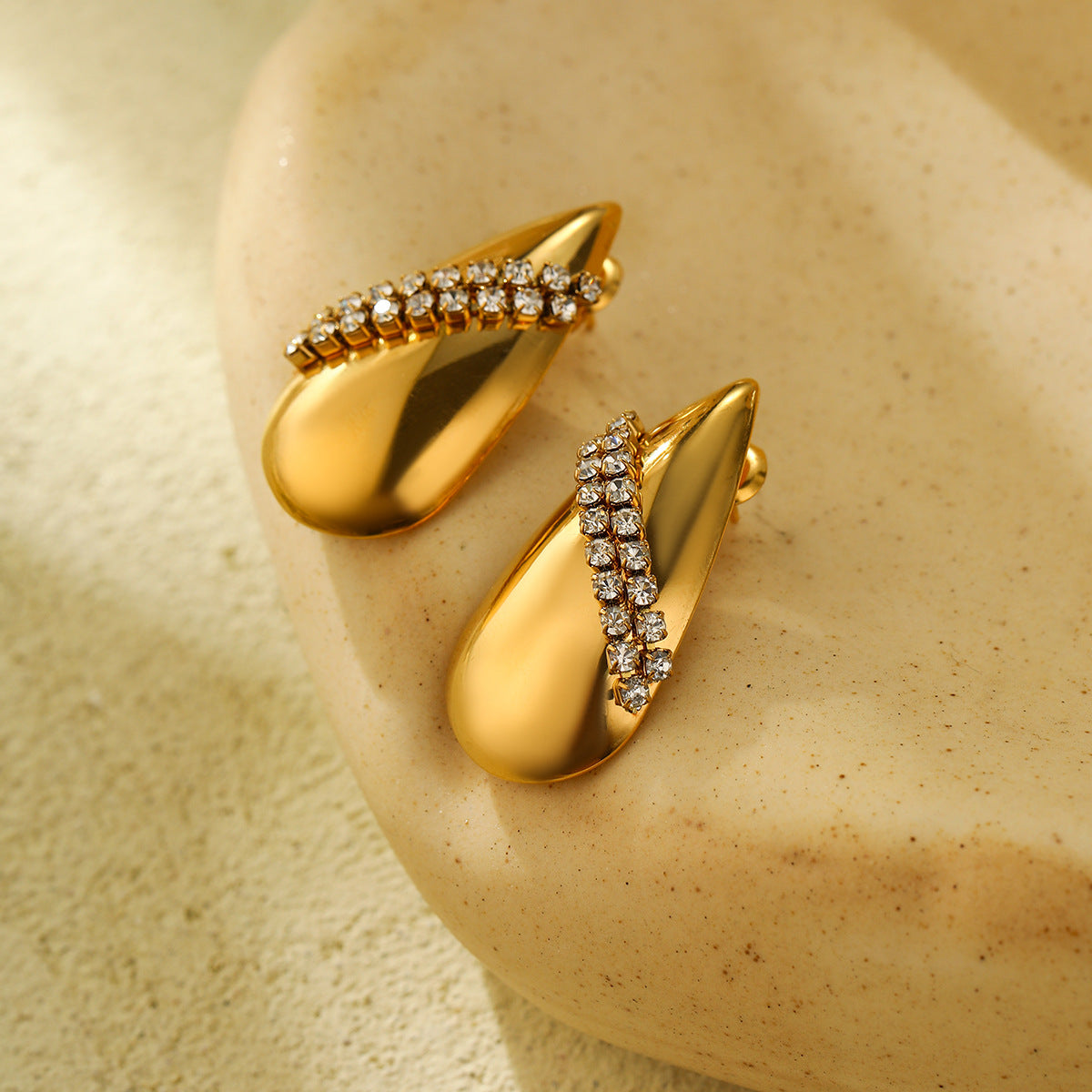 Elegantes aretes de acero titanio con forma de gota de agua para mujer, con incrustaciones de diamantes de imitación y acabado galvanizado