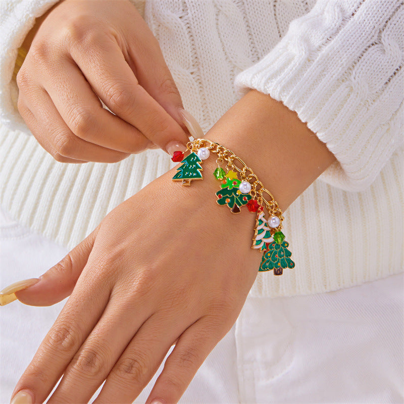 Bracciale artigianale in lega a tema natalizio con ciondolo a forma di Babbo Natale e albero di Natale, perline color caramella, accenti di perle e motivi a fiocco di neve festivi