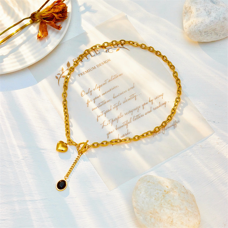 Collana con ciondolo ovale minimalista in acciaio titanio con dettaglio nappa e chiusura OT a forma di cuore