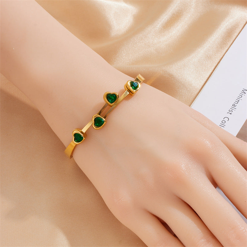 Elegante pulsera de titanio chapado en oro con circonitas en forma de corazón para mujer