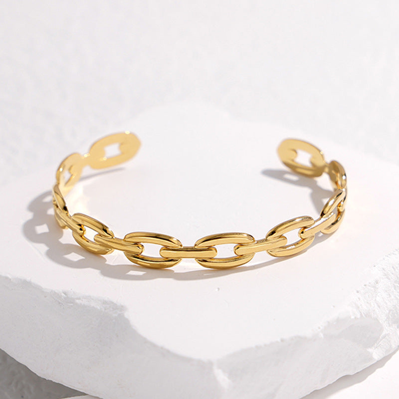 Pulsera Minimalista de Acero de Titanio Abierta para Mujer con Acabado Chapado y Detalle de Cadena