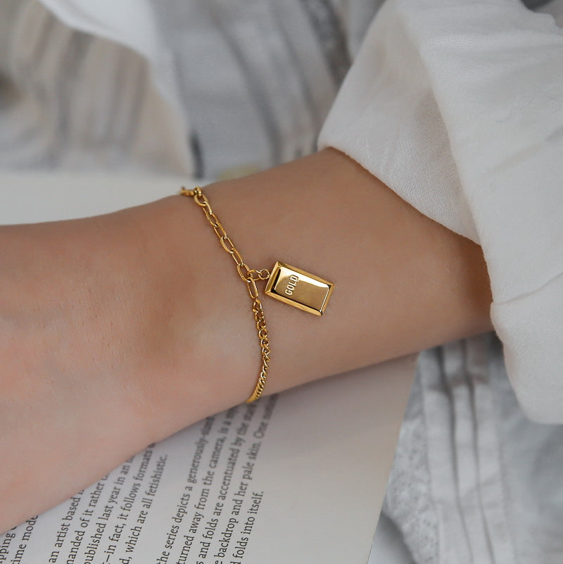 Collana da donna originale in acciaio al titanio placcato oro con design geometrico quadrato e catena ondulata