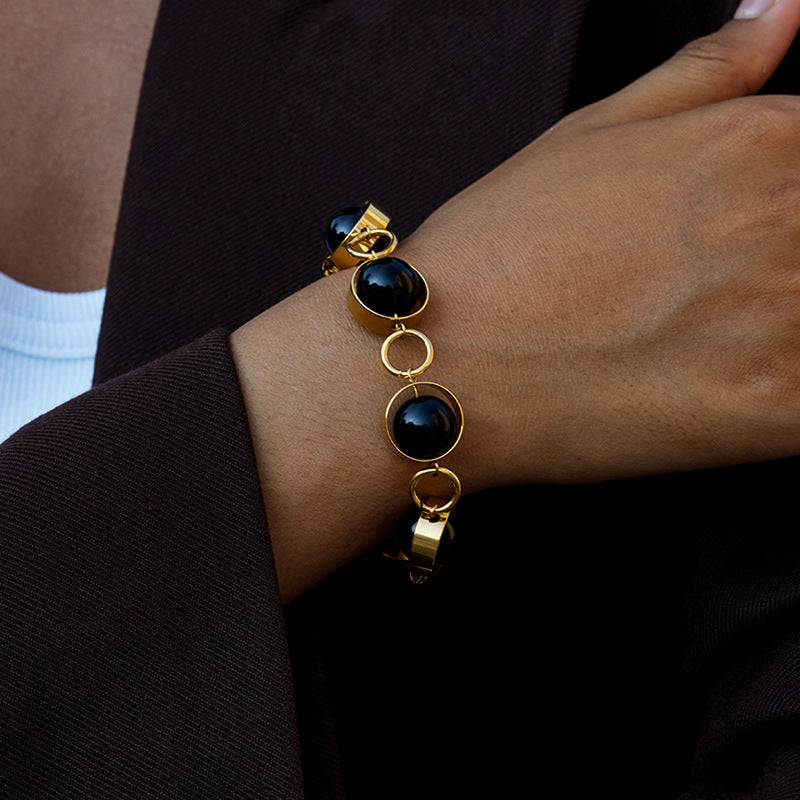 Bracciale minimalista geometrico girevole con chiusura a T in perline di vetro nero e acciaio al titanio con finitura placcata