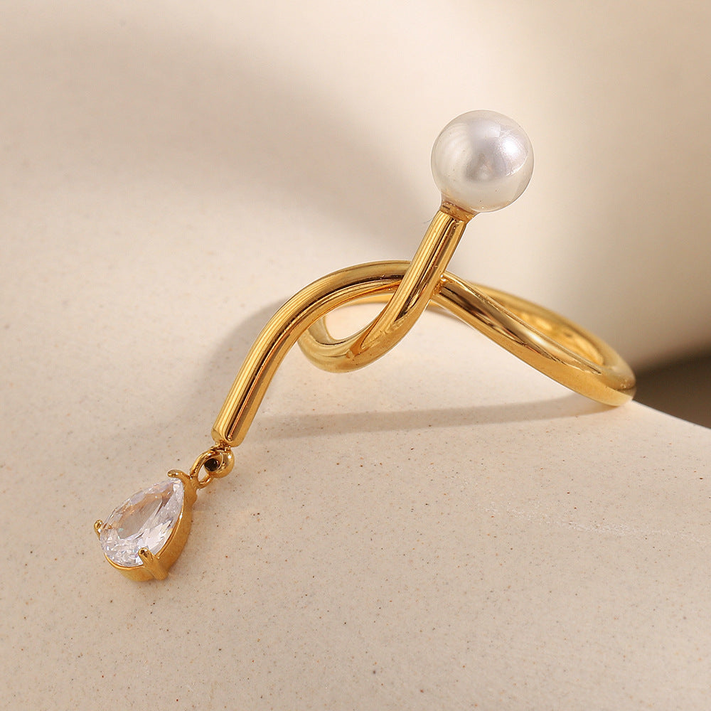 Anillo minimalista de acero inoxidable con chapado en oro de 18 quilates, detalle de nudo, acento de borla, circonita cúbica e incrustación de perlas de imitación