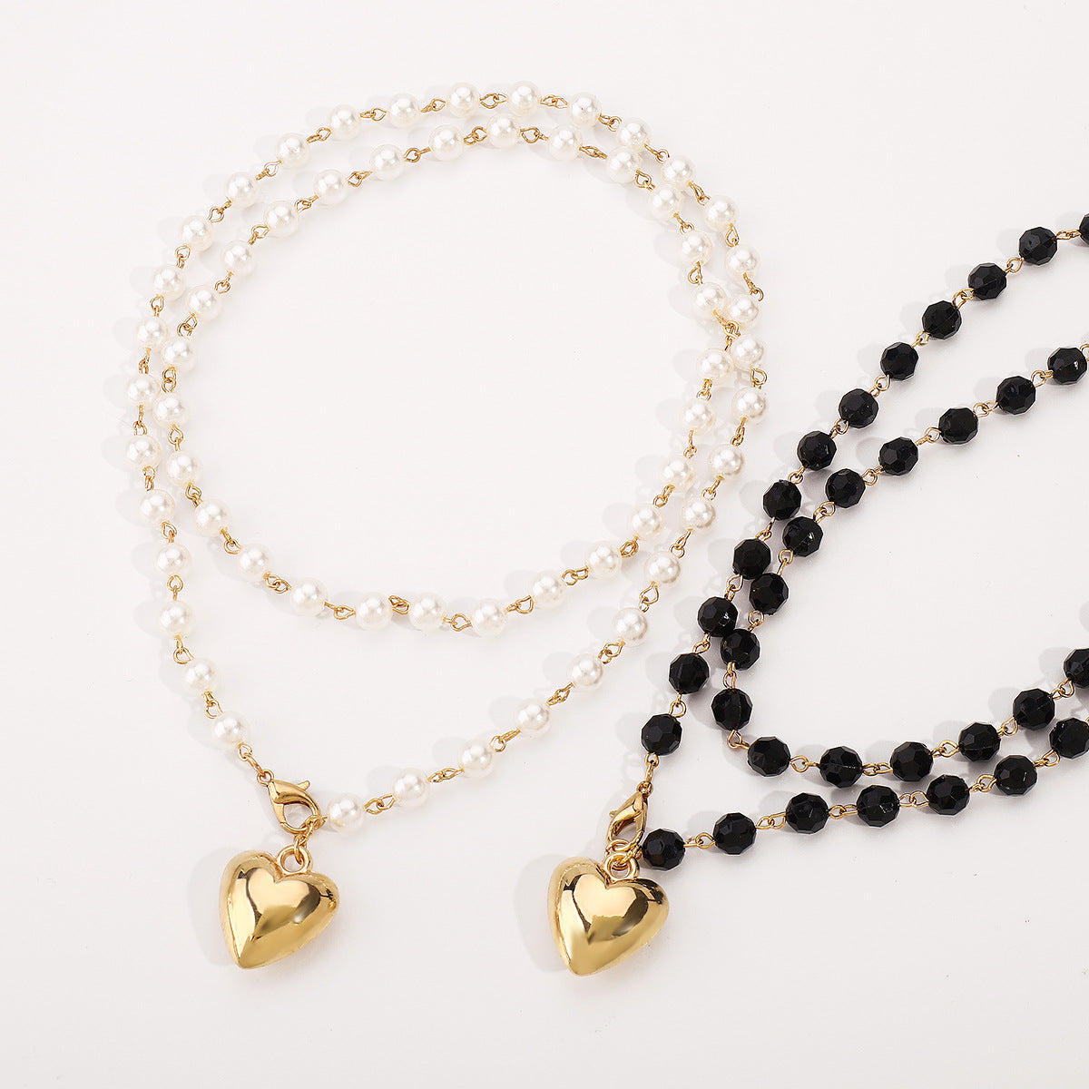 Collar de doble capa minimalista con colgante de corazón, acentos de perlas simuladas y acabado chapado en oro para mujer