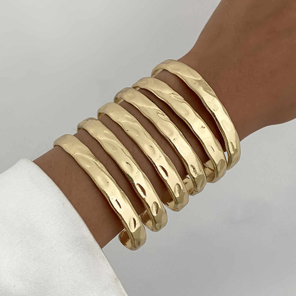 Pulsera minimalista geométrica de aleación para mujer con textura líquida martillada y acabado pulido chapado