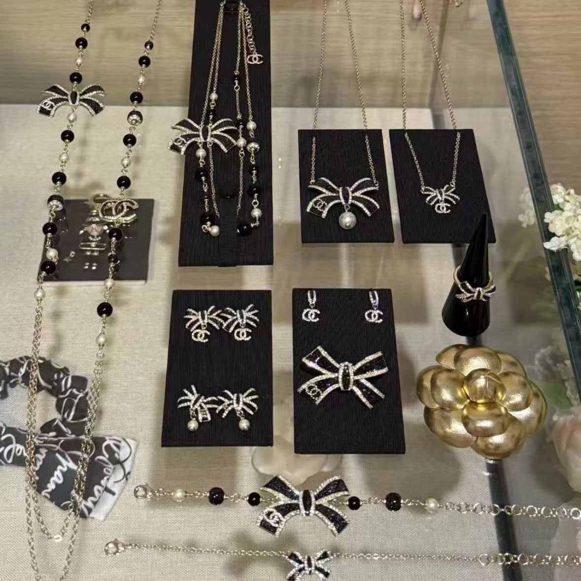Elegante set di collana e orecchini in ottone placcato oro con fiocco smaltato da donna