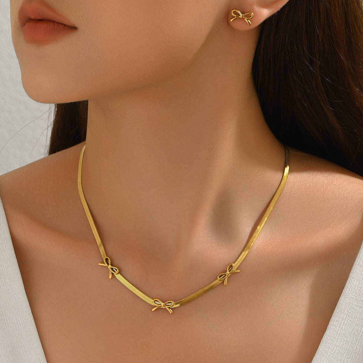 Parure collana e orecchini a fiocco da donna in acciaio inossidabile placcato oro 18 carati, stile minimalista