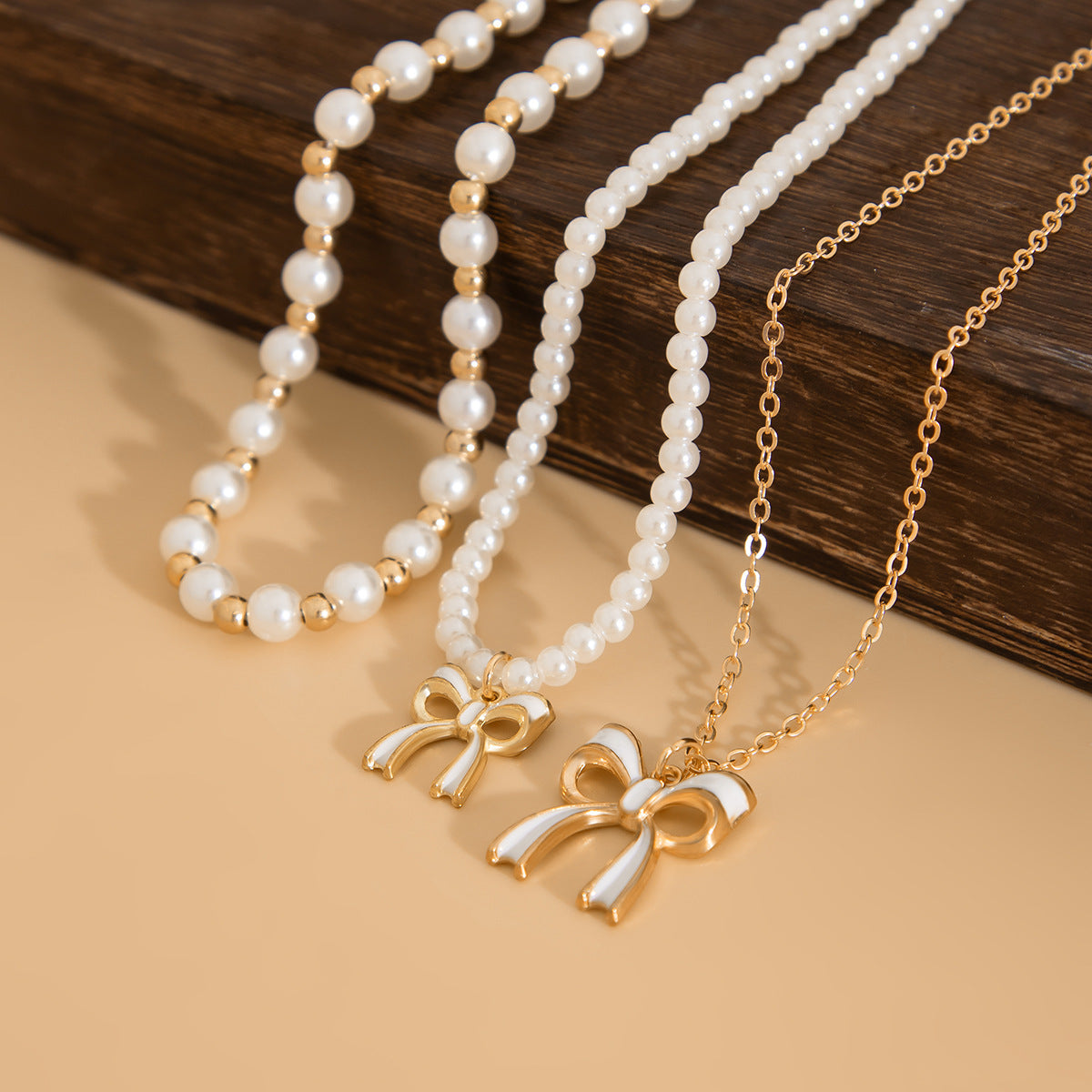 Graziosa collana pendente a forma di fiocco con dettaglio nappa, perla sintetica e lega, finitura placcata, stile a strati da donna