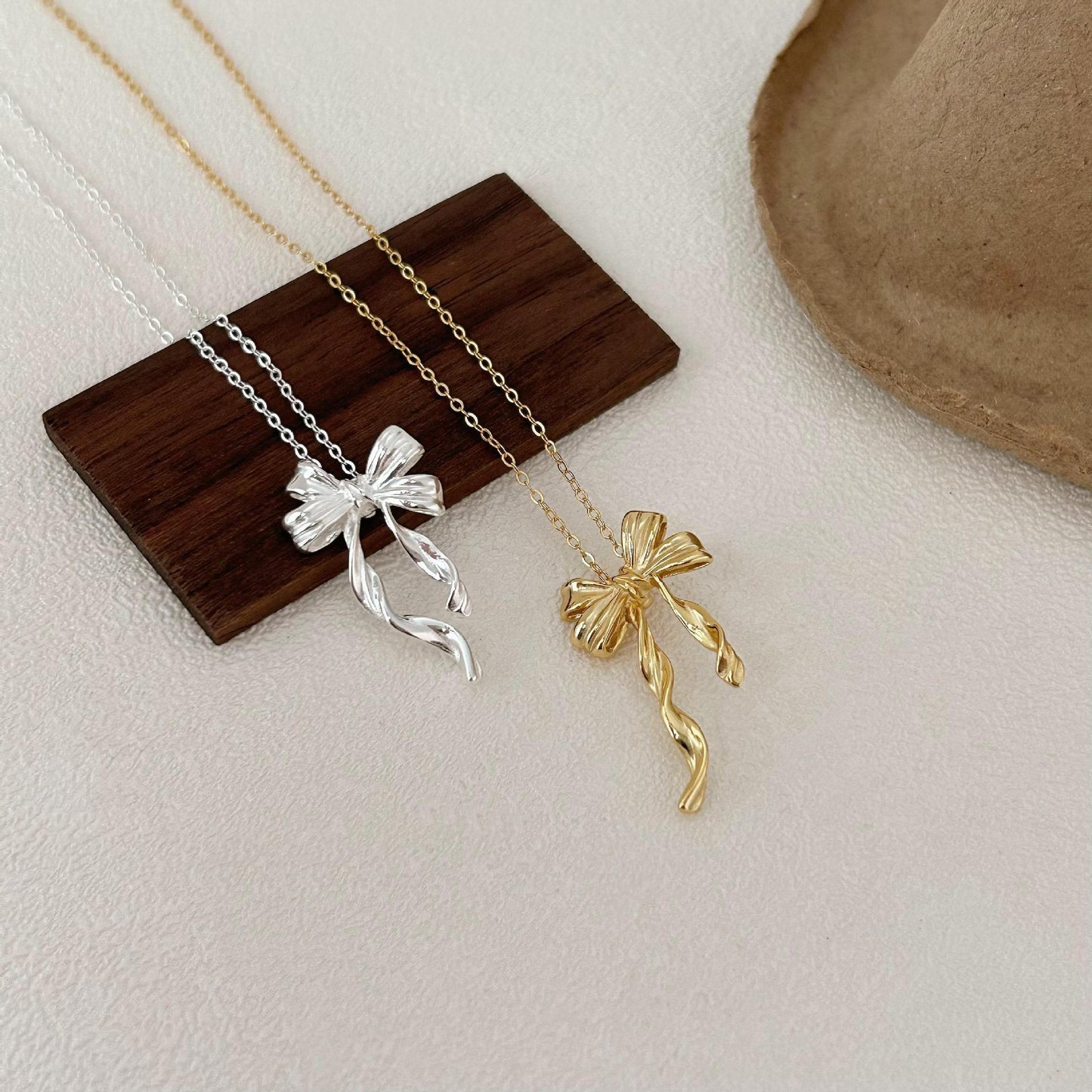 Minimalist Bow-Shaped Pendant Necklace in Sterling Silver with Gold Plating on Cross Chain