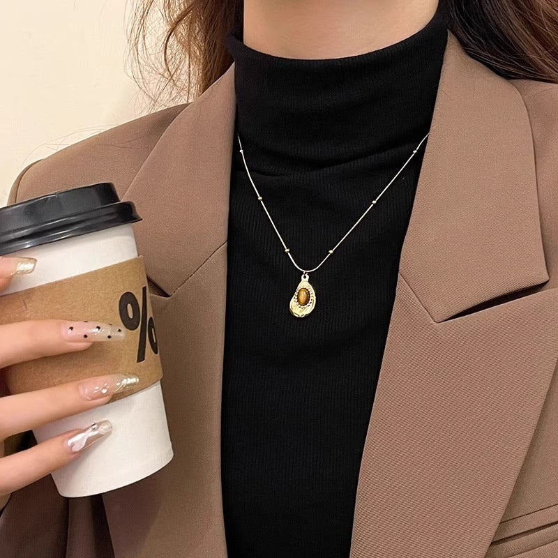 Collana da donna stile vintage in acciaio al titanio placcato oro con pendente irregolare geometrico in ambra, catena per clavicola