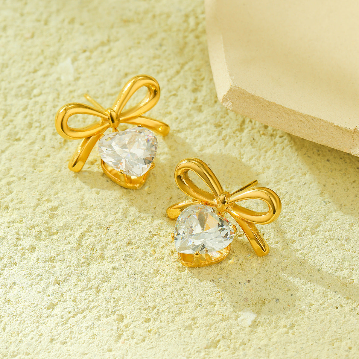 Pendientes de tuerca de acero inoxidable con forma de lazo de moda para mujer con detalles de pedrería y acabado chapado