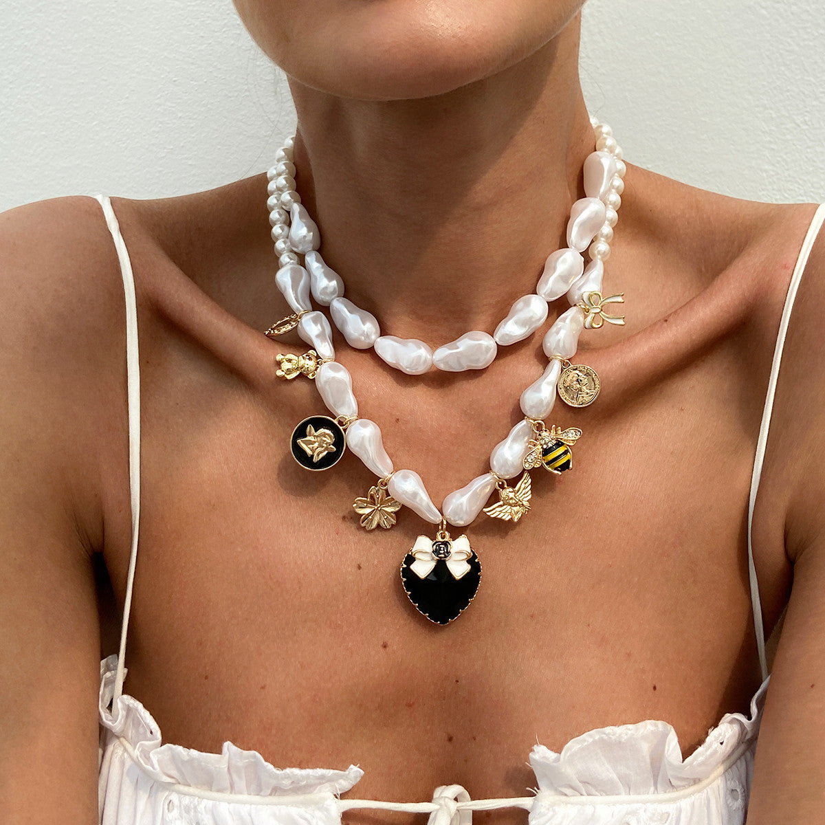 Collana con pendente a forma di ape esagerata a cuore e forma geometrica con base in lega placcata, perle imitate e intarsi in strass acrilici per donna