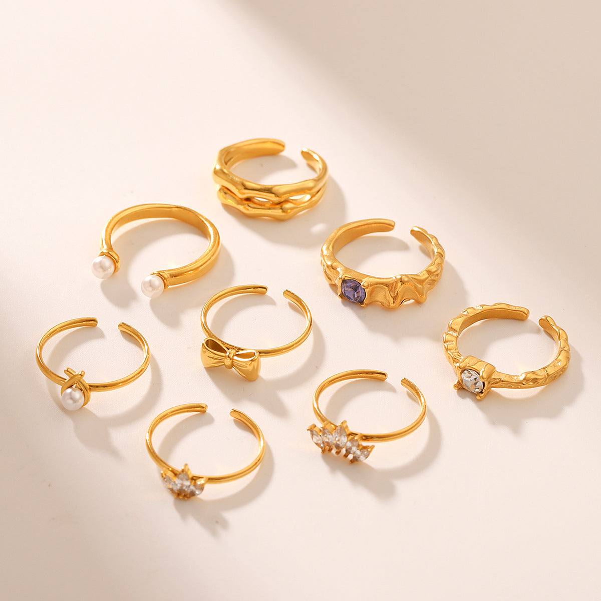 Anello da donna alla moda placcato oro 18 carati in acciaio inossidabile martellato a forma di fiocco con perla e zircone