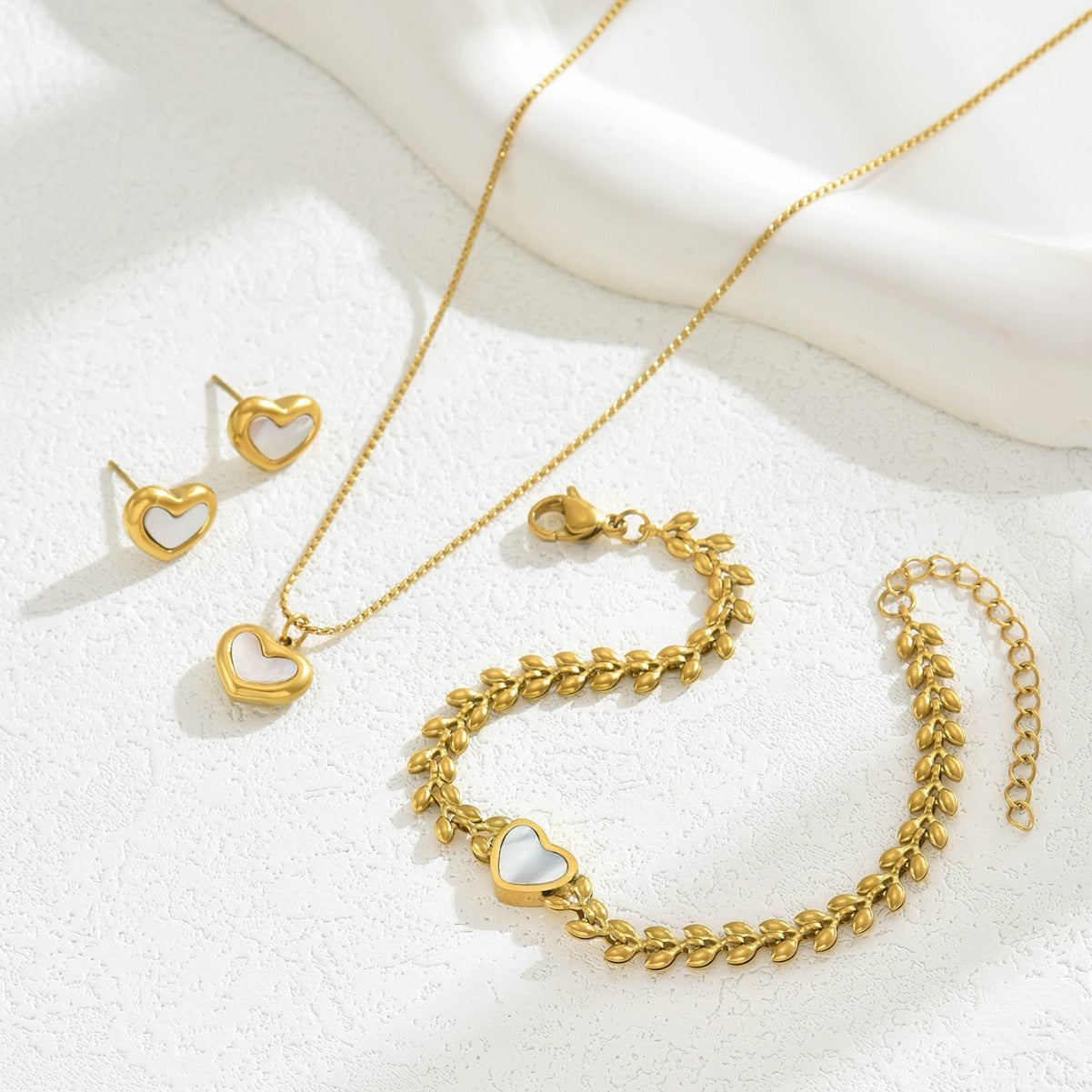 Encantador conjunto de pulsera, collar y pendientes de perlas y nácar en forma de corazón, de cobre con acabado micropavé.