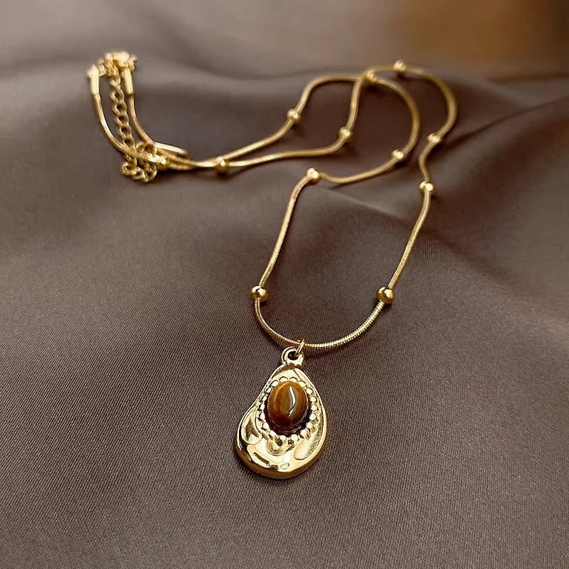 Collana da donna stile vintage in acciaio al titanio placcato oro con pendente irregolare geometrico in ambra, catena per clavicola