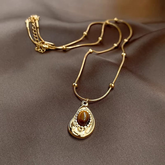 Collana da donna stile vintage in acciaio al titanio placcato oro con pendente irregolare geometrico in ambra, catena per clavicola