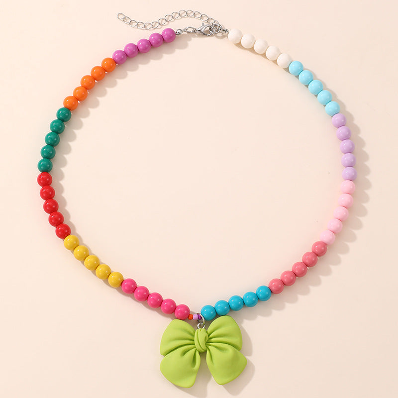 Lindo Collar de Resina con Forma de Lazo para Niñas con Acabado Pintado en Diseño Multicolor, Joyería Infantil Dulce y Juguetona