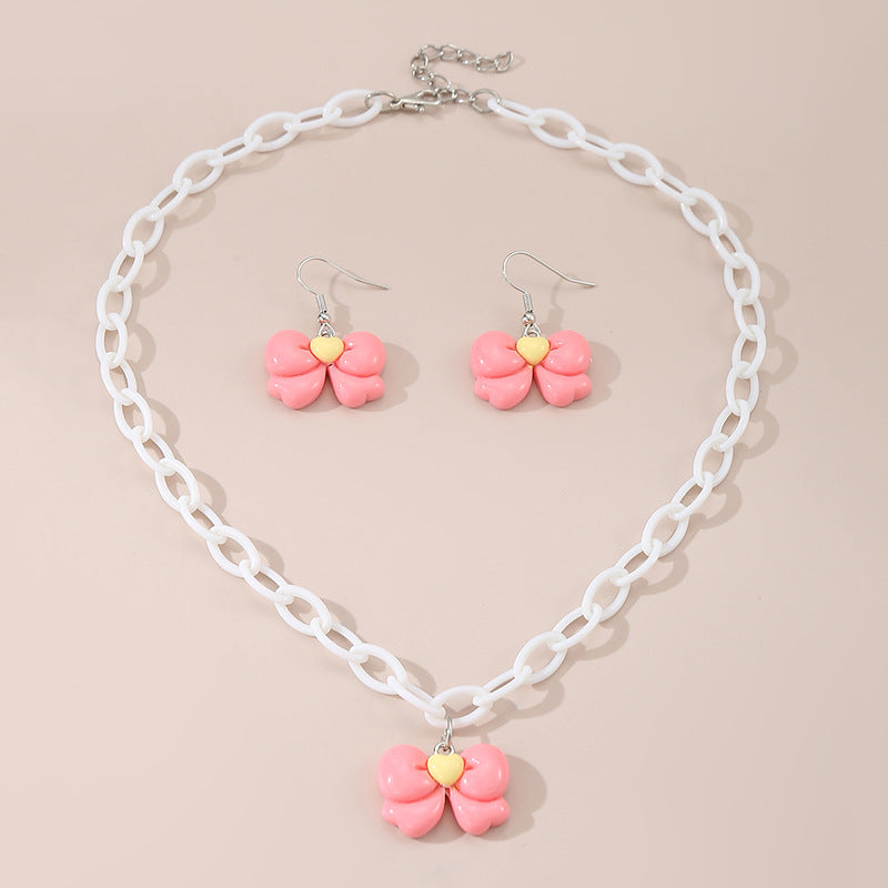 Collar con colgante de lazo acrílico minimalista color caramelo para niños con acabado esmaltado y cadena de cuentas