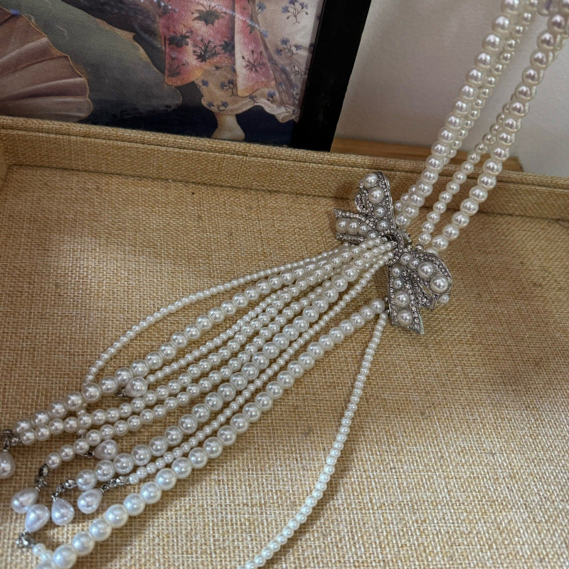 Elegante collar con colgante de lazo de diamantes de imitación de estilo francés en aleación con detalles de perlas de imitación, delicada cadena para la clavícula para mujer
