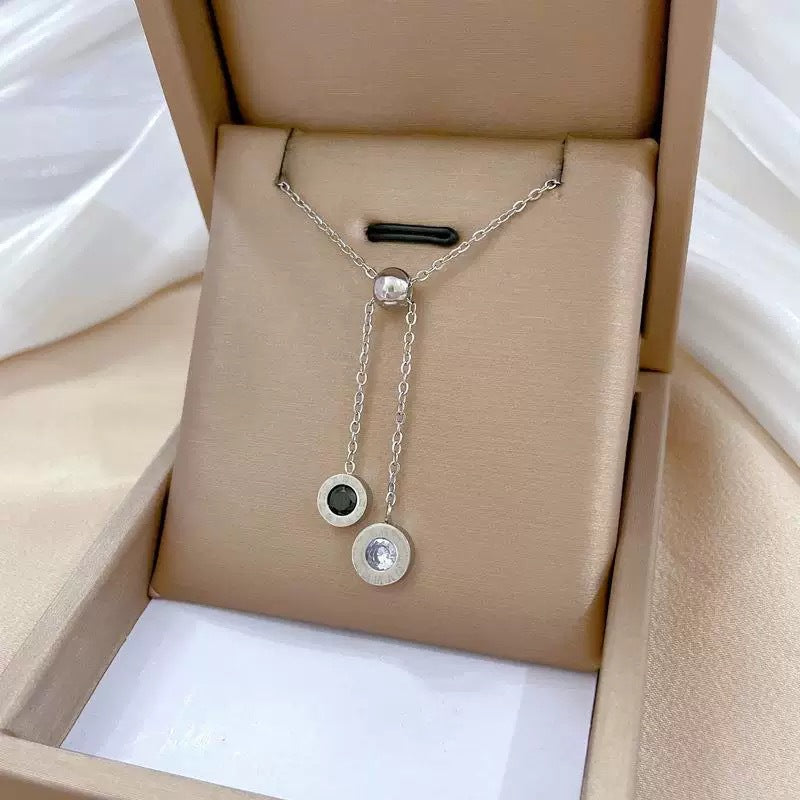Collana con ciondolo geometrico minimalista da donna in acciaio al titanio con finitura placcata, accenti in zirconia bianca e nera, stile medaglione a strati