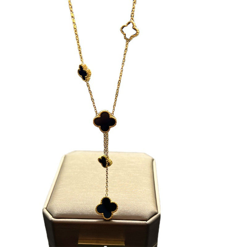 Collana con ciondolo a trifoglio minimalista in acciaio al titanio con placcatura in oro e dettaglio a nappa su catena a O