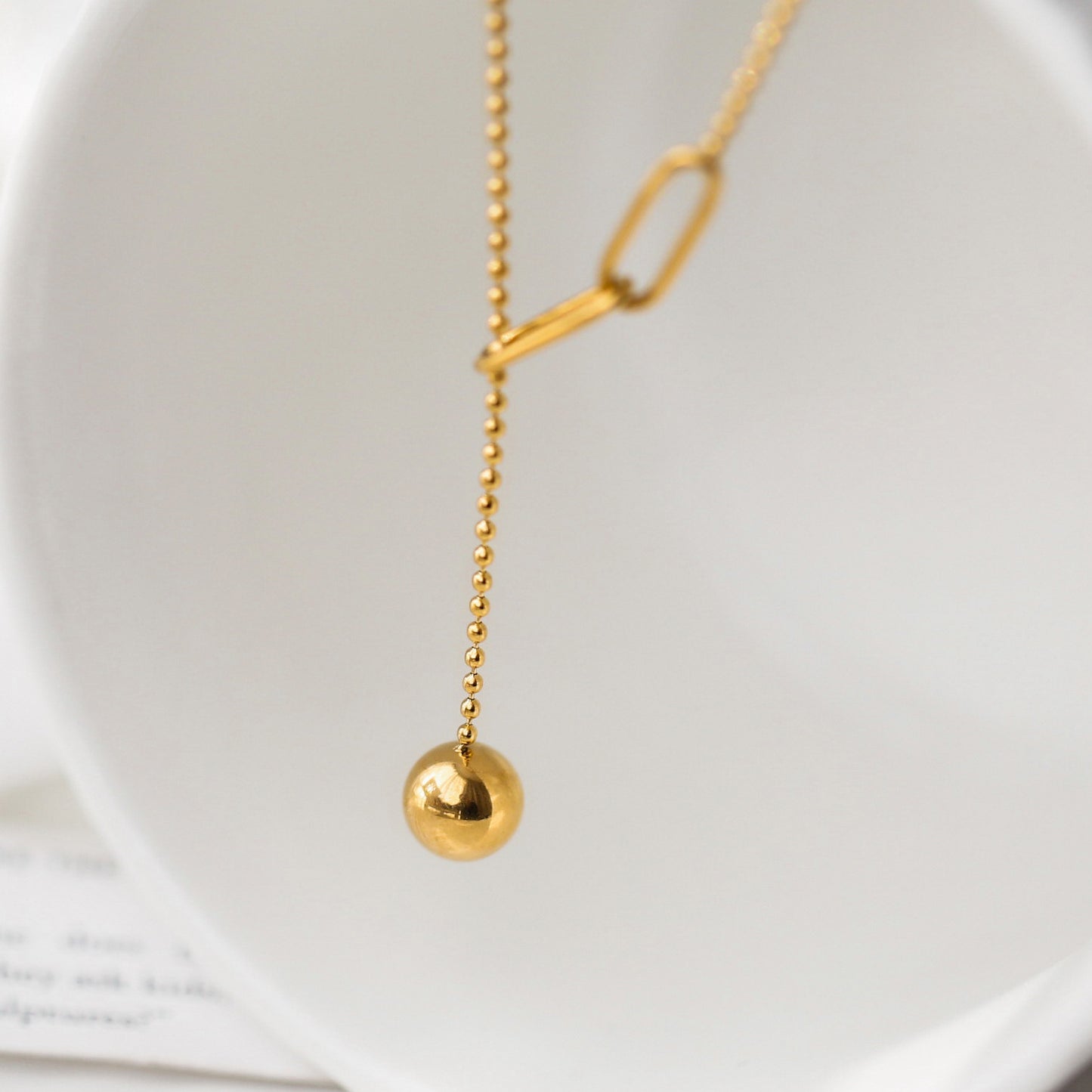 Collana a sospensione geometrica minimalista in acciaio al titanio da donna, con nappa e dettaglio regolabile con sfera a tirante
