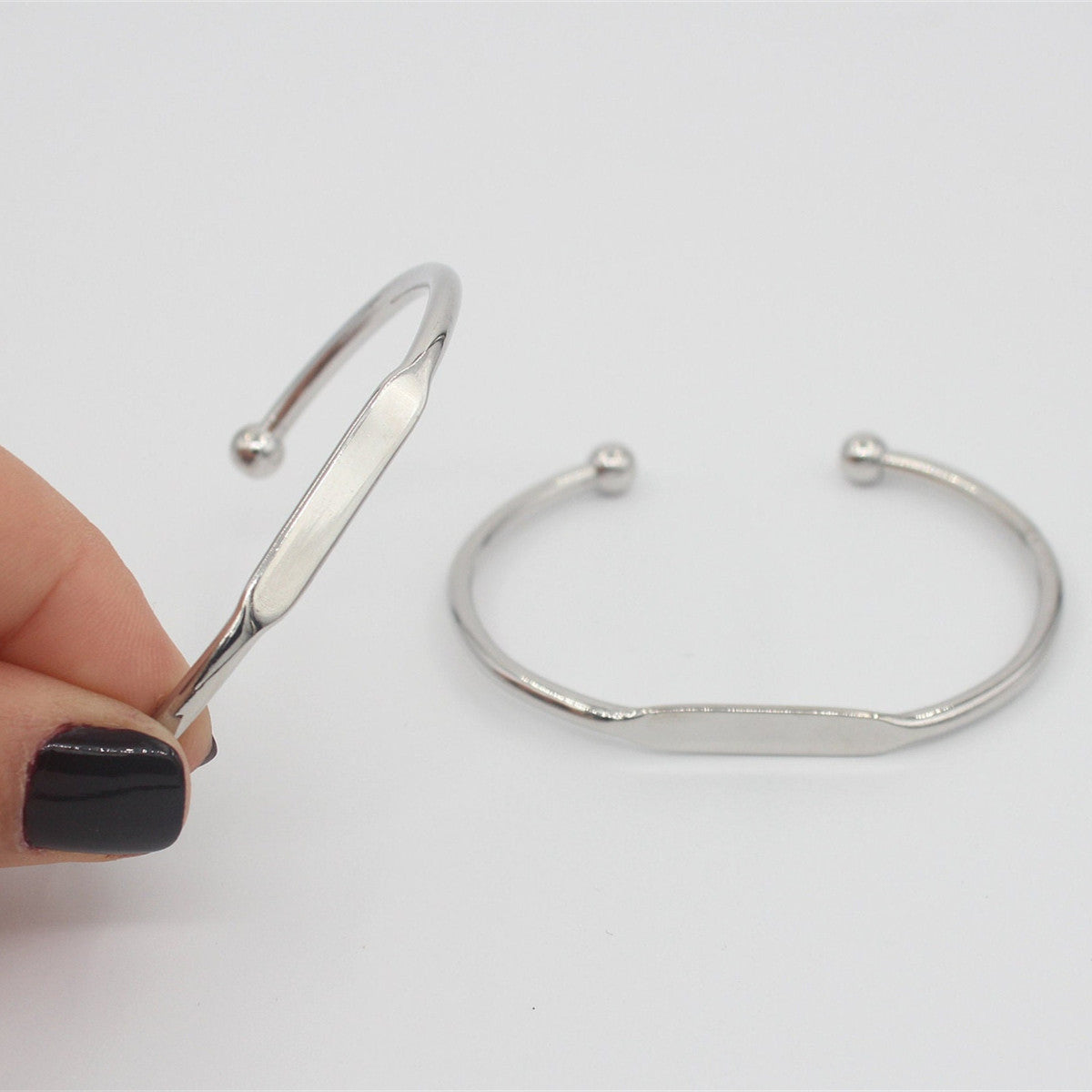 Bracciale rigido aperto a forma di C in acciaio inossidabile lucido, con barra per charm