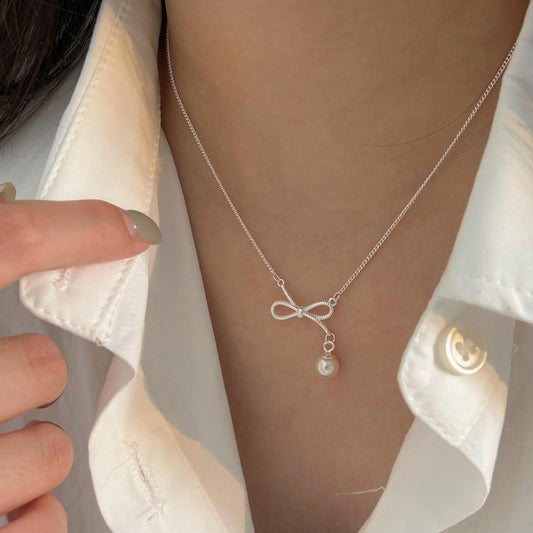 Collar minimalista con forma de lazo en plata de ley 925 con perla de acento en cadena de cruz