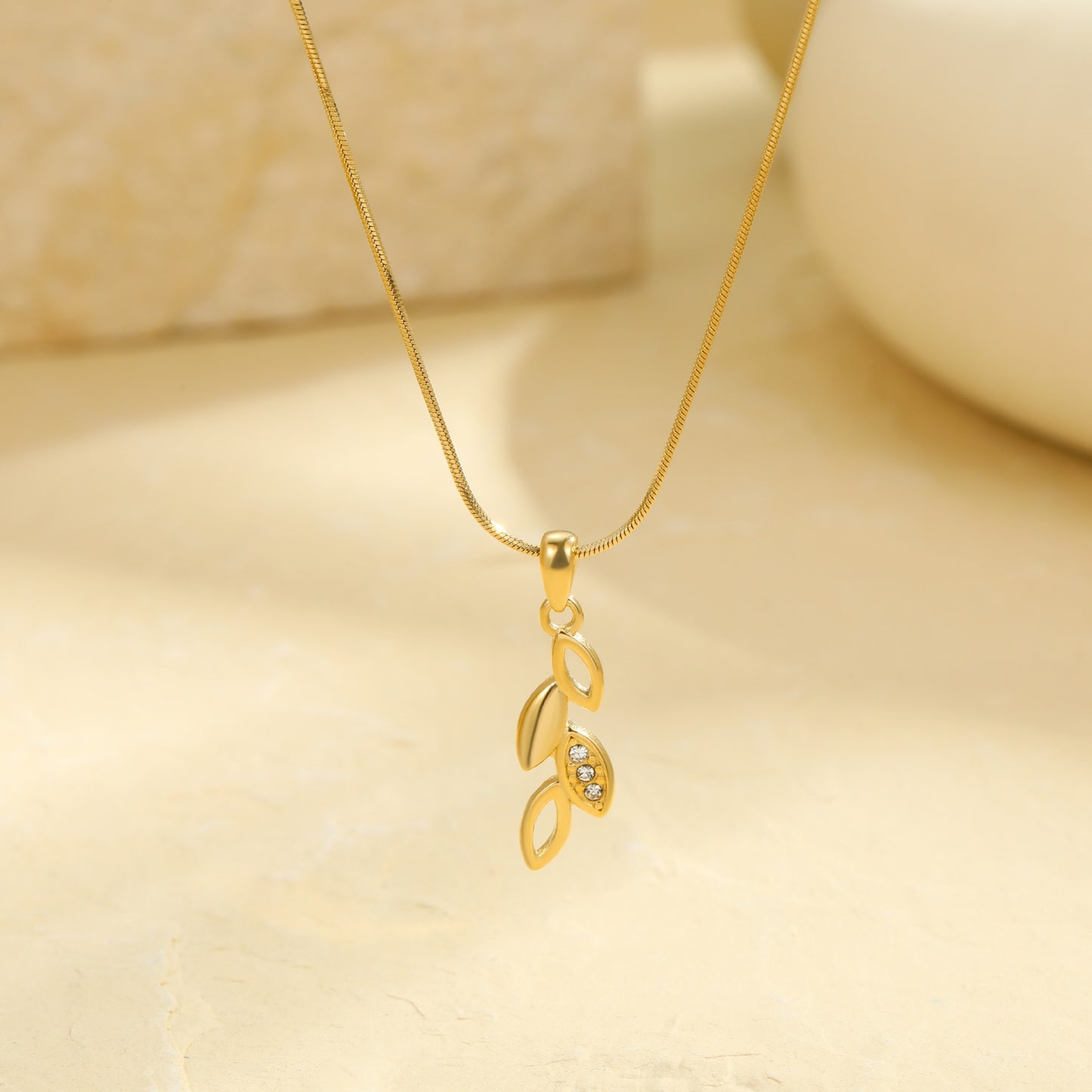 Collar con dije de hoja floral minimalista y aretes de acero inoxidable con incrustaciones de diamantes de imitación y acabado chapado