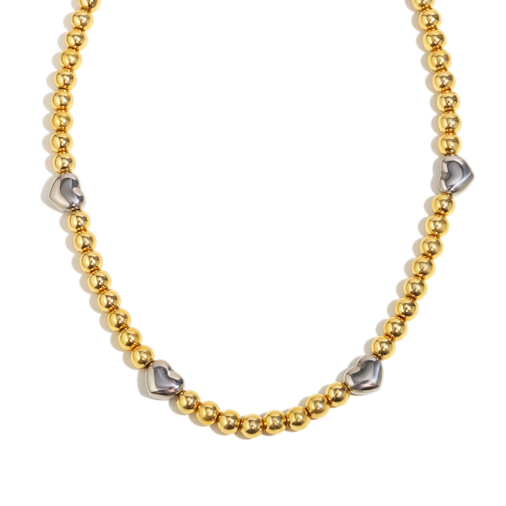 Collar de acero inoxidable minimalista con forma de corazón, chapado en oro de 18 quilates y detalle de cuentas.