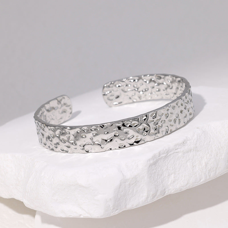 Bracciale a fascia regolabile in acciaio al titanio con trama irregolare e finitura placcata da donna