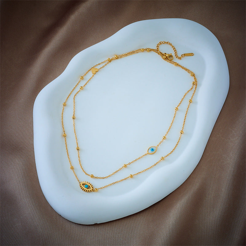 Collar con Colgante de Ojo Azul Hueco de Doble Capa Minimalista de Moda en Acero de Titanio con Cuentas Doradas y Acabado Esmaltado