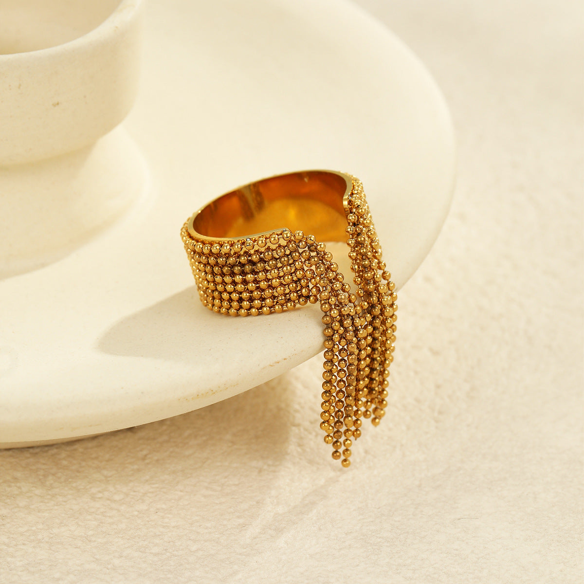 Anillo minimalista geométrico de acero inoxidable con acabado chapado y detalle de borla para mujer