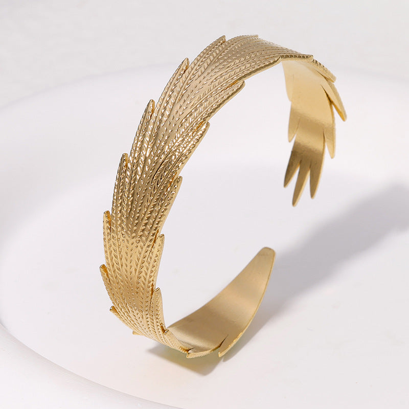 Pulsera de acero inoxidable con forma de pluma minimalista y acabado chapado para mujer