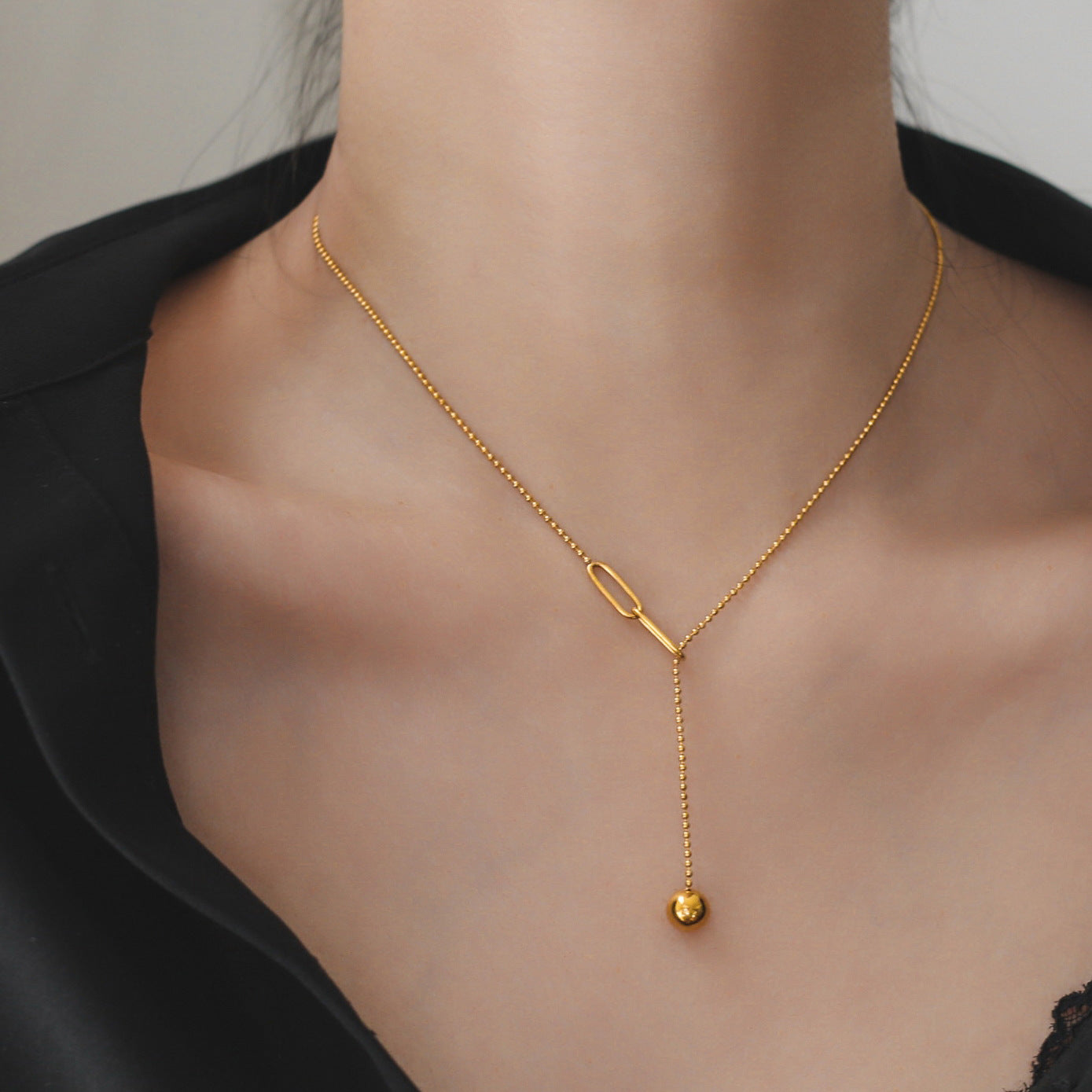 Collana a sospensione geometrica minimalista in acciaio al titanio da donna, con nappa e dettaglio regolabile con sfera a tirante