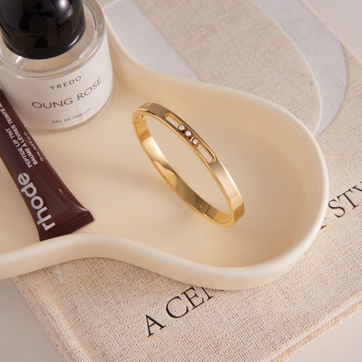 Pulsera minimalista ajustable de acero titanio chapado en oro con detalles de circonitas blancas para mujer