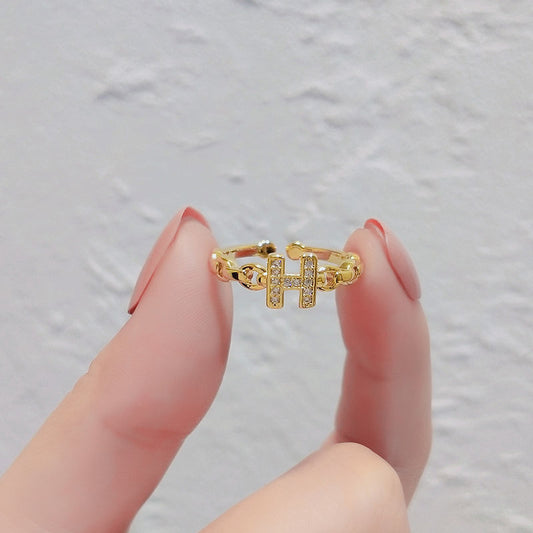 Anello minimalista con lettera H in ottone placcato oro con dettagli in strass e fascia aperta regolabile