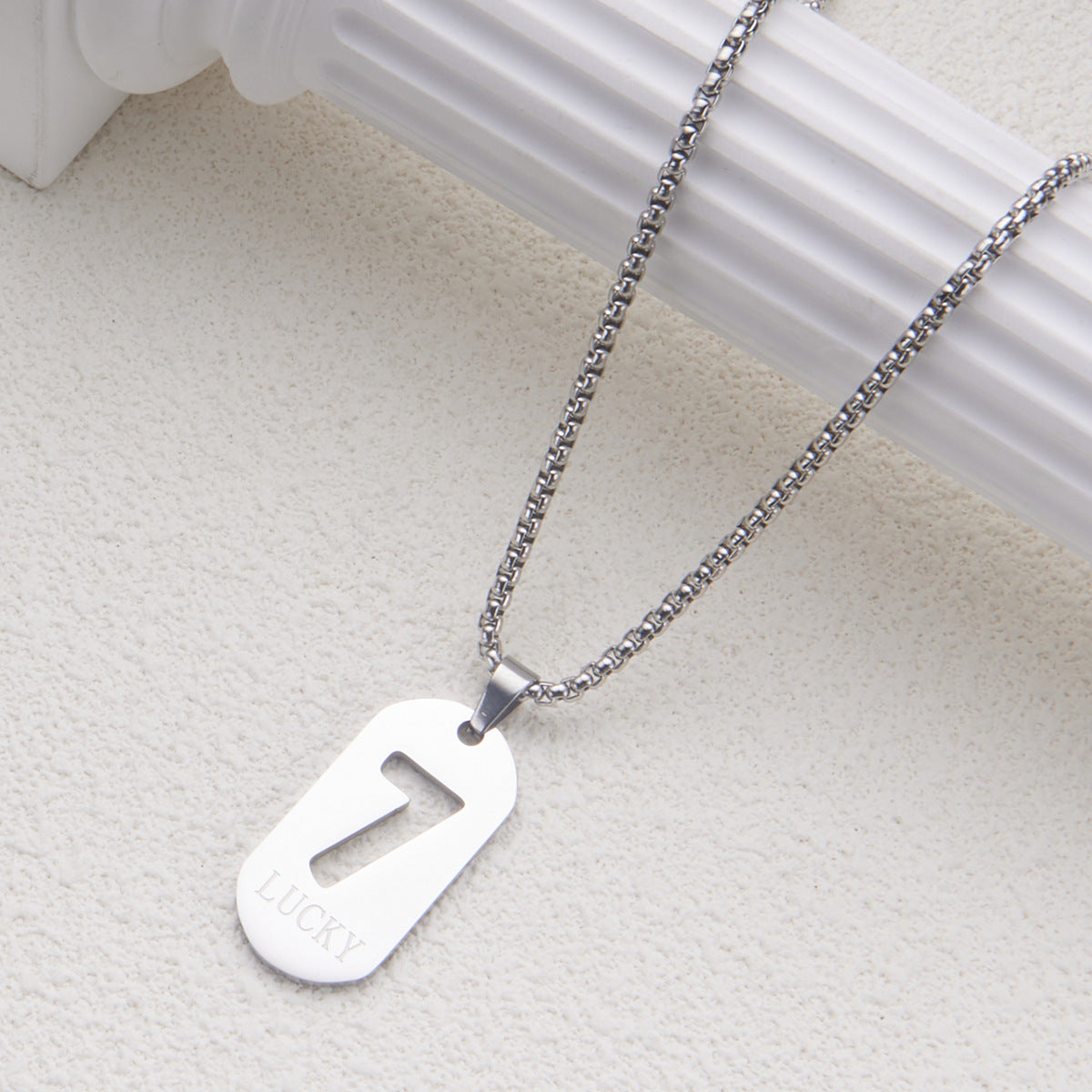 Collar con colgante minimalista del número de la suerte 7 en acero de titanio con acabado pulido para mujer y hombre