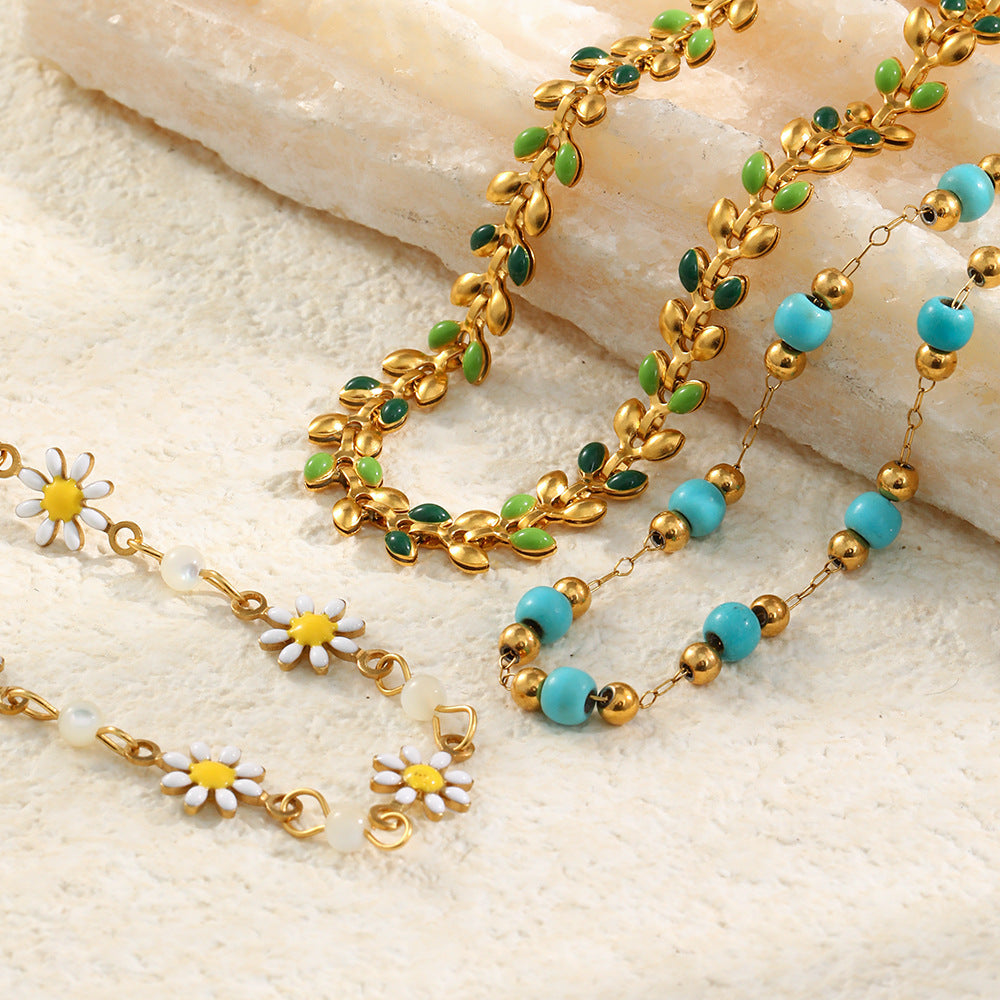 Pulsera minimalista de acero inoxidable con dije de margarita, detalles esmaltados y chapado en oro de 18 quilates para mujer