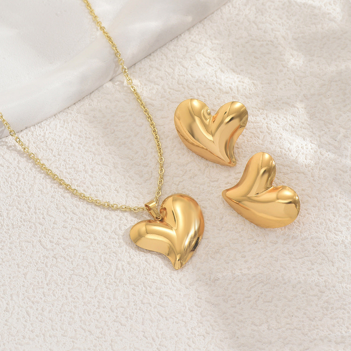 Collana con pendente a cuore geometrico minimalista e orecchini coordinati in lega con finitura galvanica da donna
