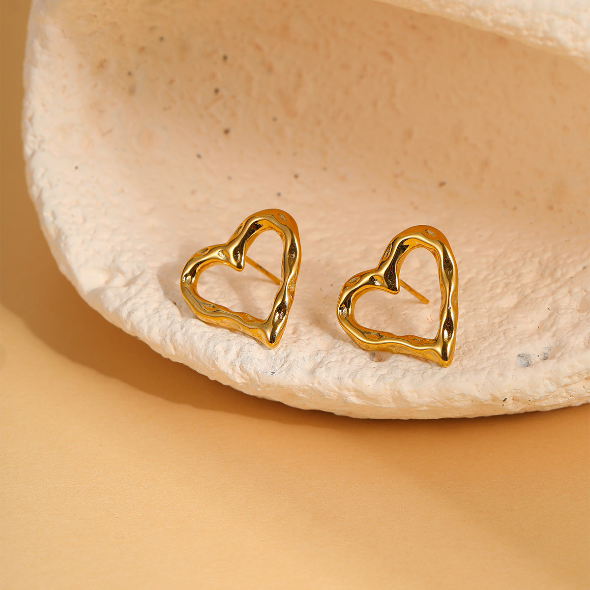 Pendientes de tuerca de corazón hueco de acero de titanio de moda minimalista con baño de oro de 18 quilates para mujer