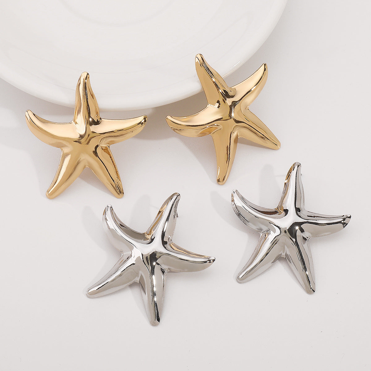 Pendientes minimalistas de aleación con forma de estrella de mar y acabado chapado para mujer. Tachuelas geométricas inspiradas en el océano tropical.