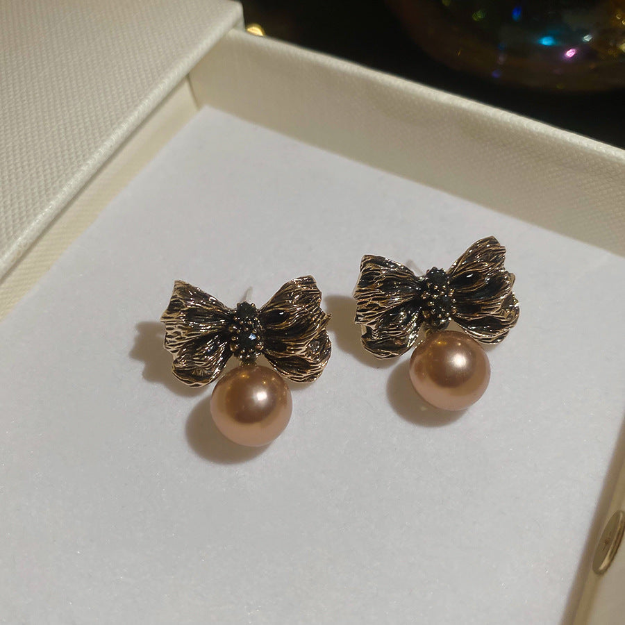 Pendientes de aleación con forma de lazo Retro Chic con detalles de perlas y baño de oro para mujer