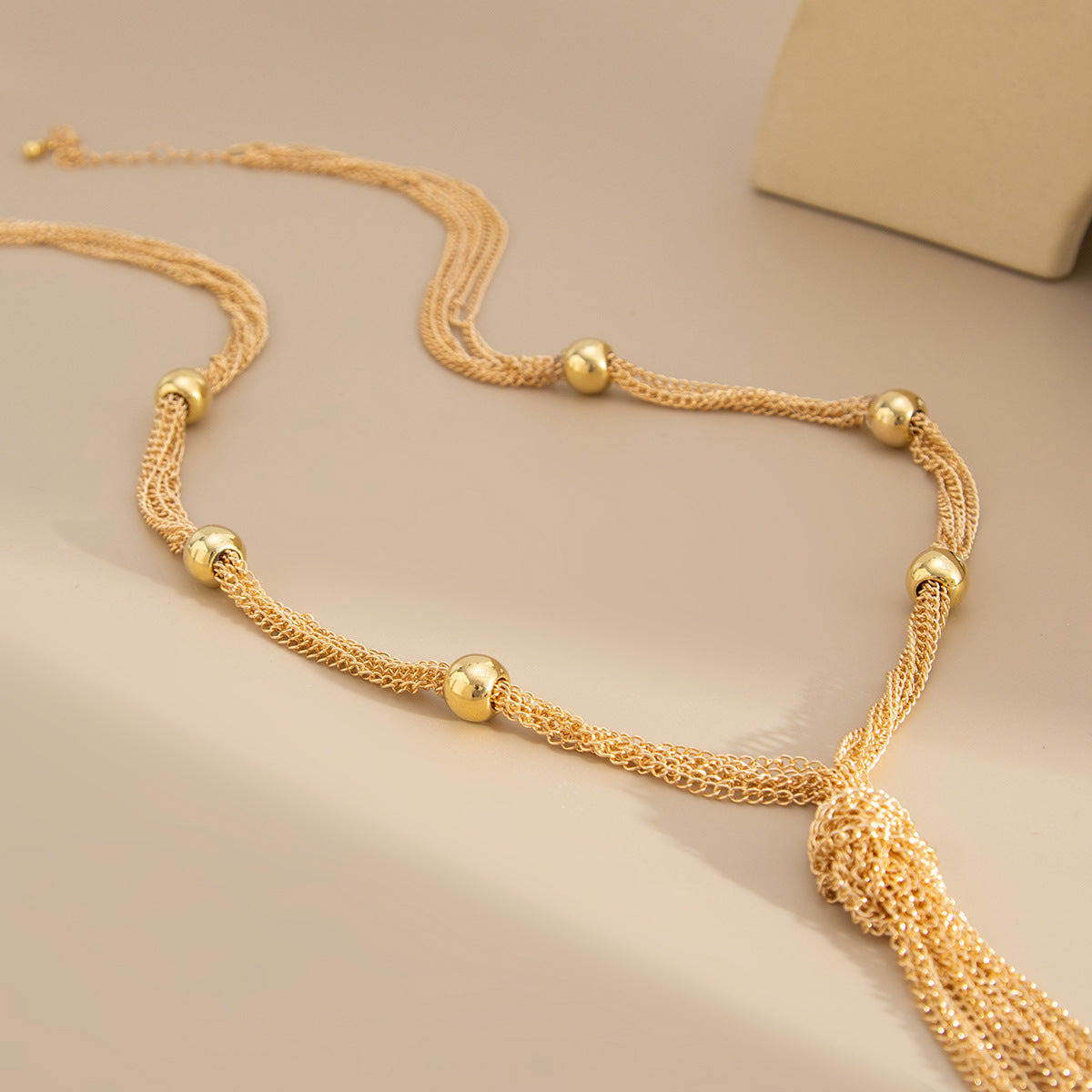Collar de mujer minimalista y geométrico con diseño en Y, con capas de metal y colgante de borla