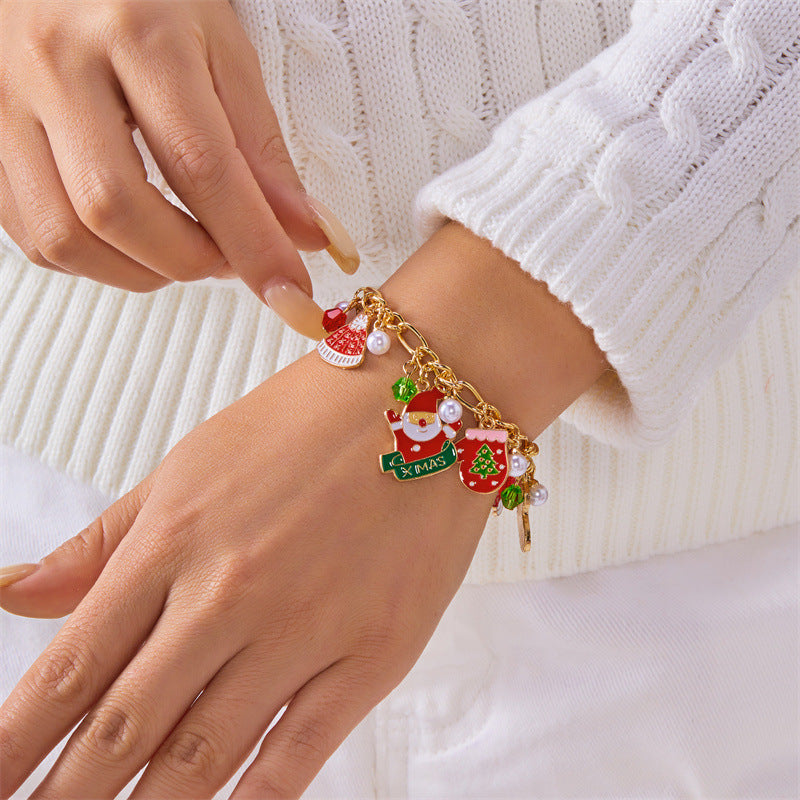 Bracciale artigianale in lega a tema natalizio con ciondolo a forma di Babbo Natale e albero di Natale, perline color caramella, accenti di perle e motivi a fiocco di neve festivi