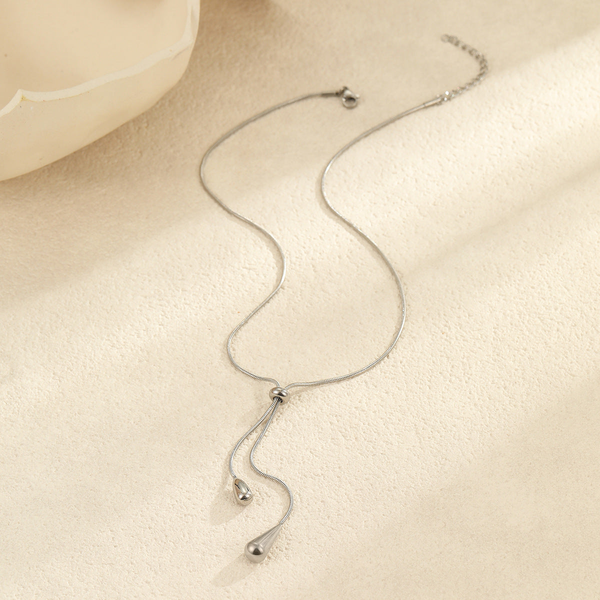 Collar minimalista con colgante de gota de acero de titanio tono frío con baño de oro para mujer
