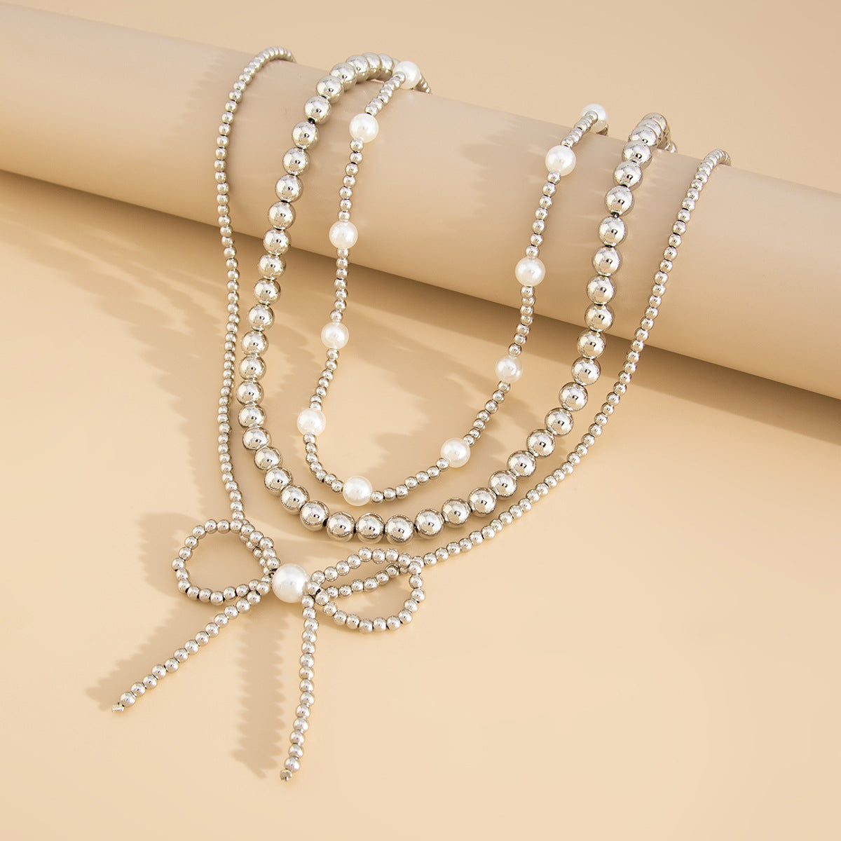 Collana da donna minimalista a forma di fiocco con perle finte e CCB, catena a sfere con perline e design multistrato